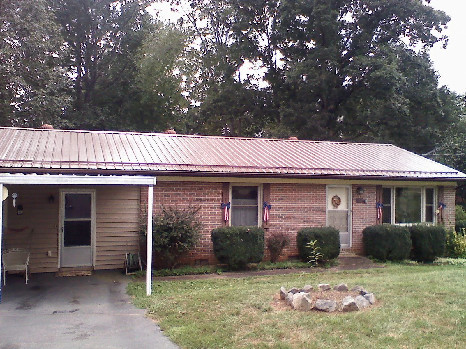 Bronze metal roof and carport on a brick ranch home — Roof Repair work by our crew in Kenton